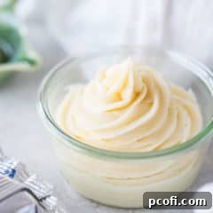 Small glass bowl containing cream cheese frosting piped in a swirl with a star tip.