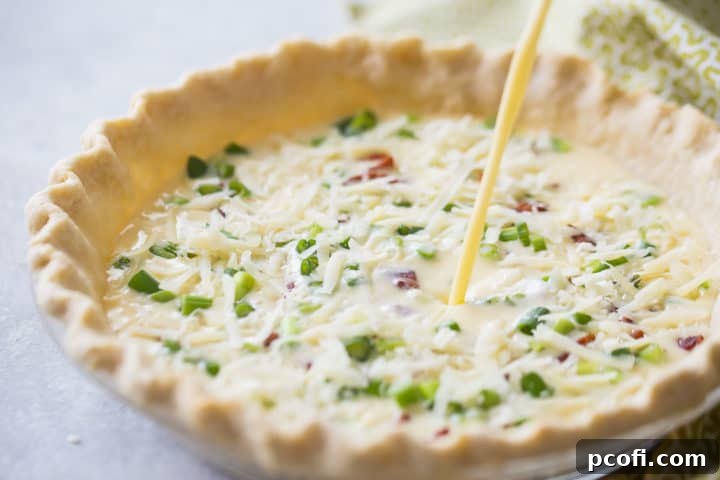 Pouring the creamy egg and milk custard mixture into the pie shell, which already contains the bacon, cheese, and scallions.