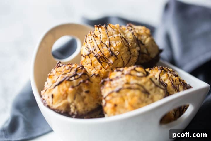 Bowl full of coconut macaroons with dark chocolate drizzle.