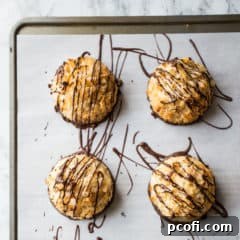 Overhead close-up shot of coconut macaroons drizzled with dark chocolate.