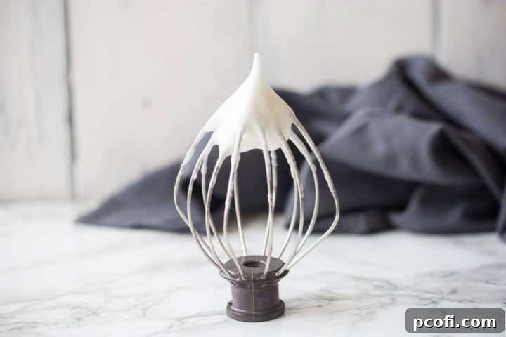 Whipped egg whites on a whisk.