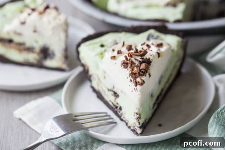 Slice of grasshopper pie on a white plate with a fork.
