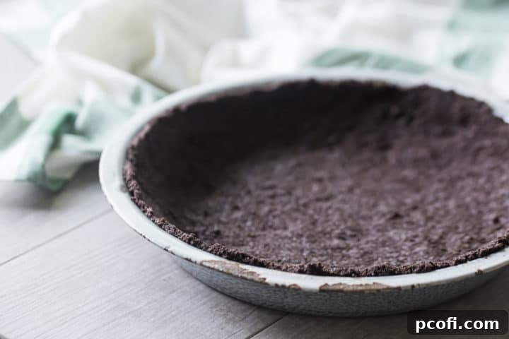 Homemade oreo cookie crust in a vintage enamel pie dish.