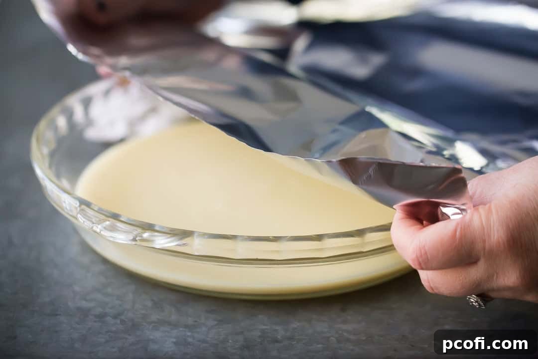Covering sweetened condensed milk with aluminum foil.