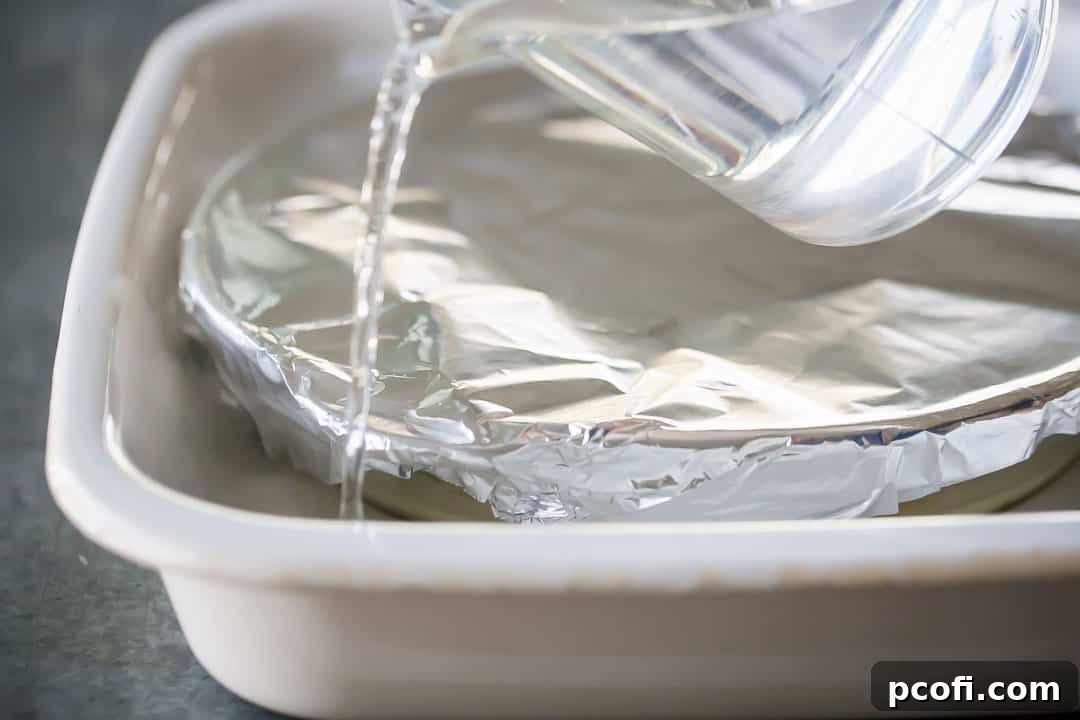 Pouring hot water into a larger pan to make a water bath.
