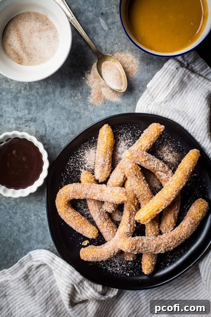 A stunning arrangement of authentic Mexican churros on a dark, rustic plate, surrounded by small bowls brimming with rich dulce de leche, sweet cinnamon sugar, and decadent chocolate sauce, showcasing perfect dipping options.