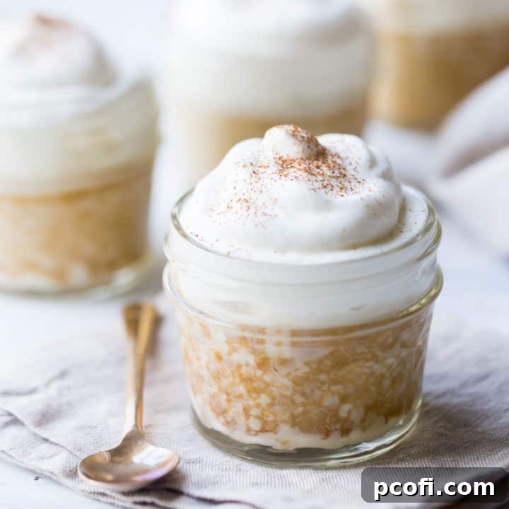 Tres leches cake baked in a small jar, topped with whipped cream and drizzled with dulce de leche.