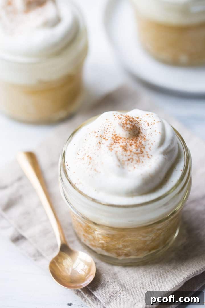 Tres leches cake baked in a jar with a gold spoon and a linen napkin.
