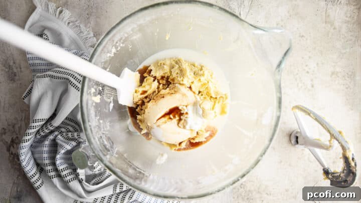 Adding liquid ingredients to chocolate chip cake batter.