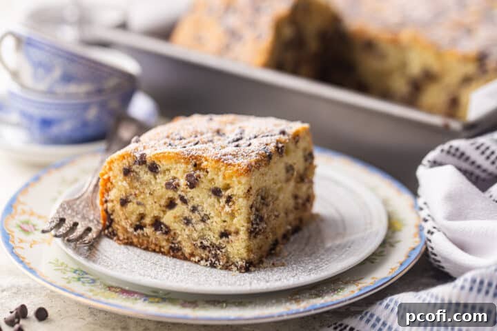 A square slice of homemade chocolate chip cake on a vintage plate, ready to be enjoyed.