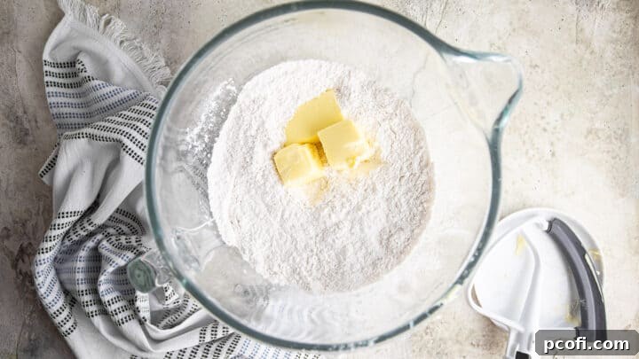 Adding soft butter to dry ingredients.
