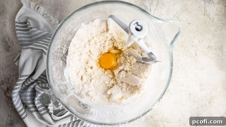 Adding the first egg to chocolate chip cake batter.