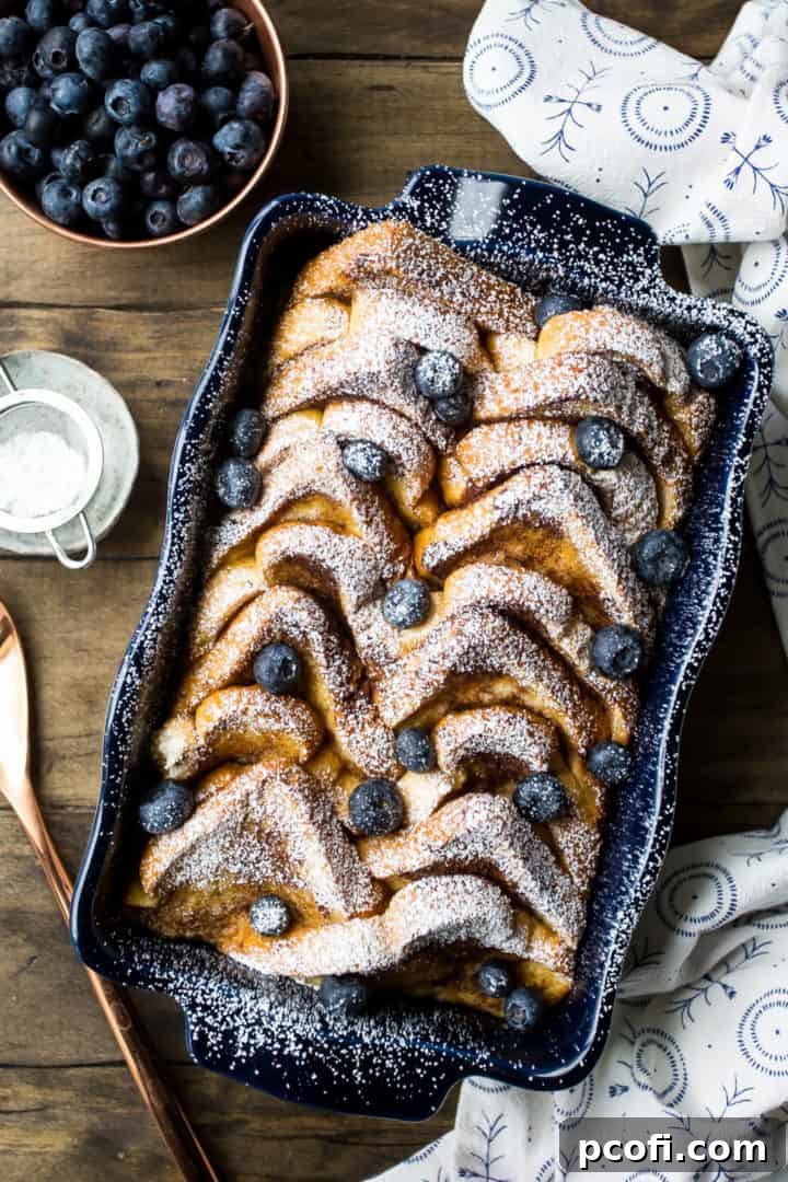 Overhead view of easy baked French toast casserole with powdered sugar and blueberries.