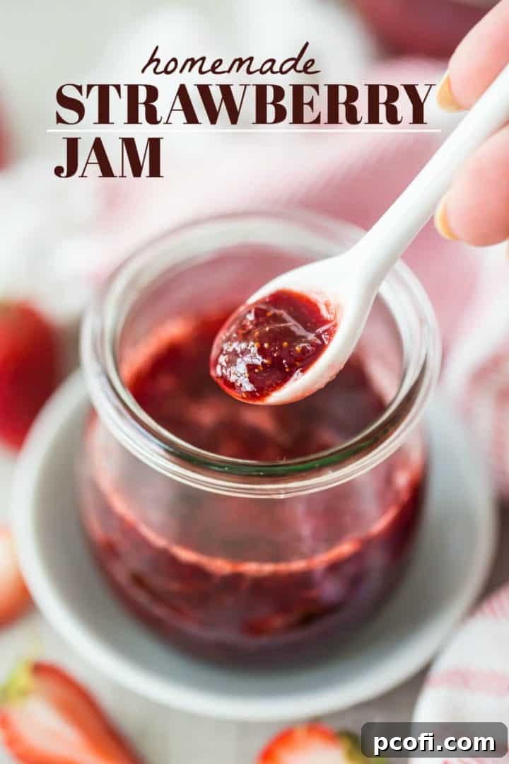 Spooning homemade strawberry jam out of a jar, with a text overlay reading "Homemade Strawberry Jam."