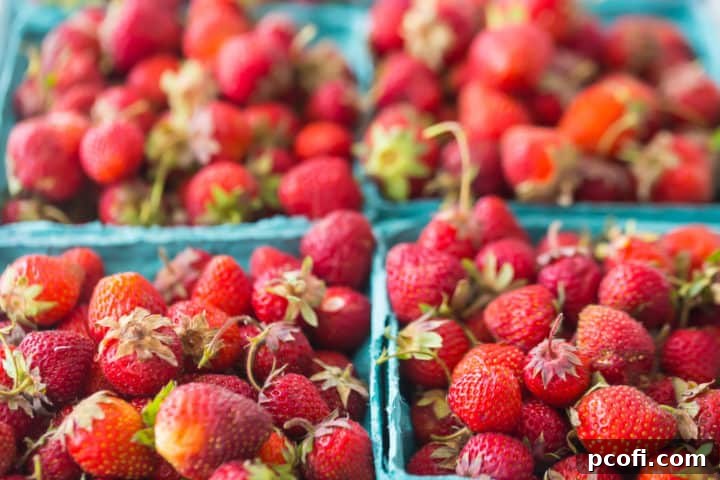 Four pounds of hand-picked strawberries in paper baskets.