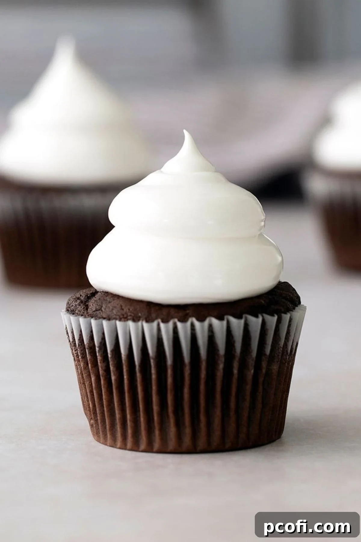 Decadent chocolate cupcakes adorned with beautifully piped marshmallow frosting.
