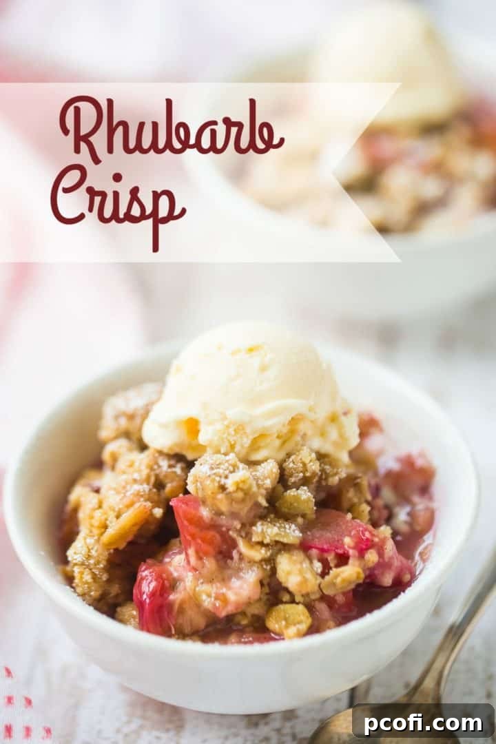Two bowls of rhubarb crisp with vanilla ice cream on a distressed white wood background.