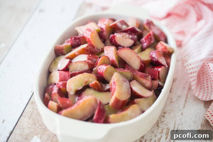Rhubarb crisp filling in a white ceramic baking dish.