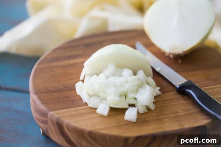 Chopped onion on a wooden cutting board.