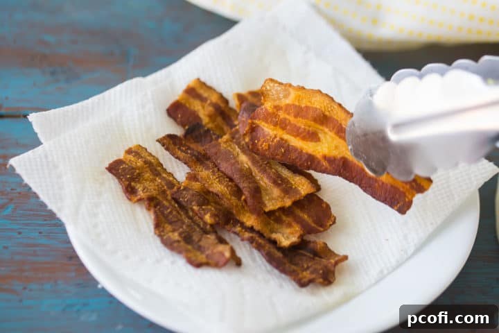 Placing cooked bacon on a plate lined with paper towels.