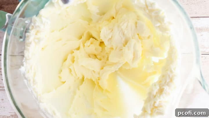 Smooth cream cheese cheesecake mixture in a large glass bowl.