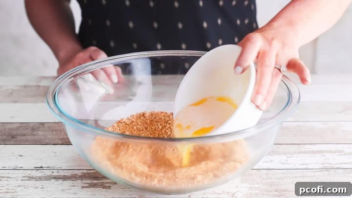 Adding melted butter to graham cracker crust.
