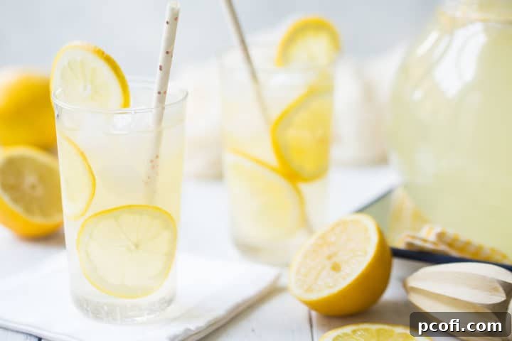 Glasses of homemade lemonade, surrounded by fresh lemons.