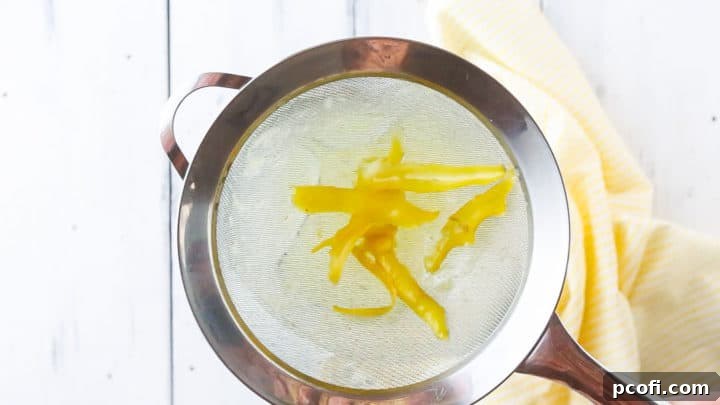 Straining peels out of lemon simple syrup.