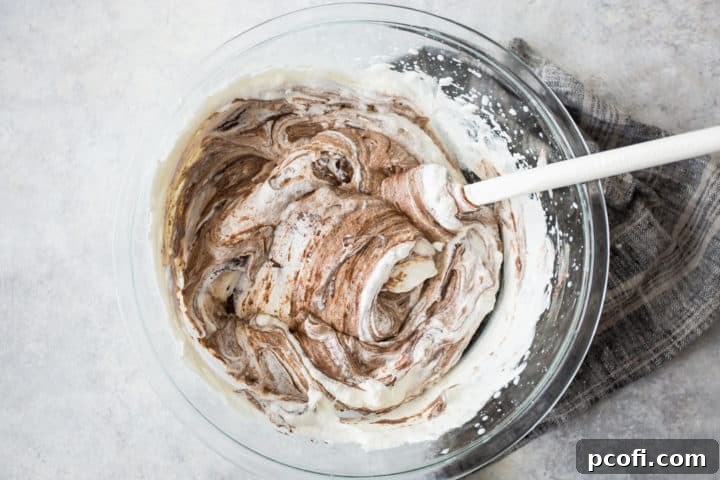 Folding chocolate into whipped cream.