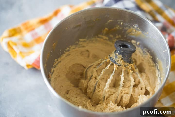 Mixing bowl of peanut butter mousse with a whisk attachment.