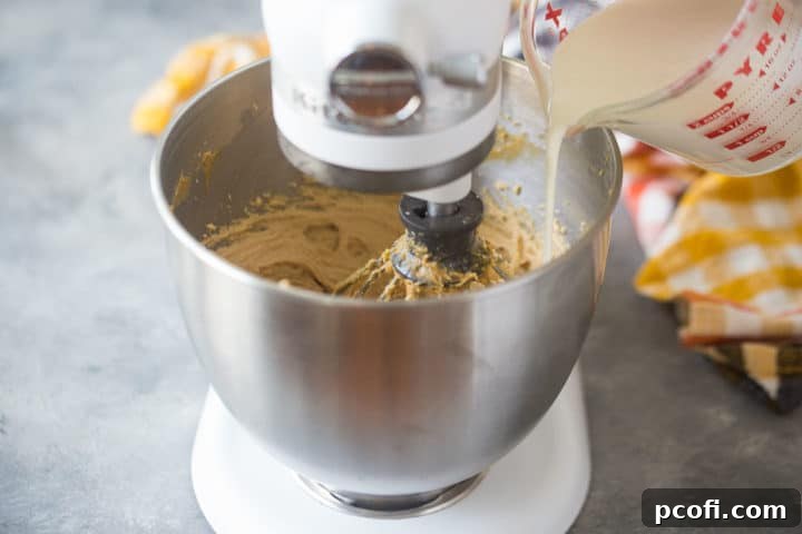 Drizzling whipping cream into peanut butter mousse while whipping.