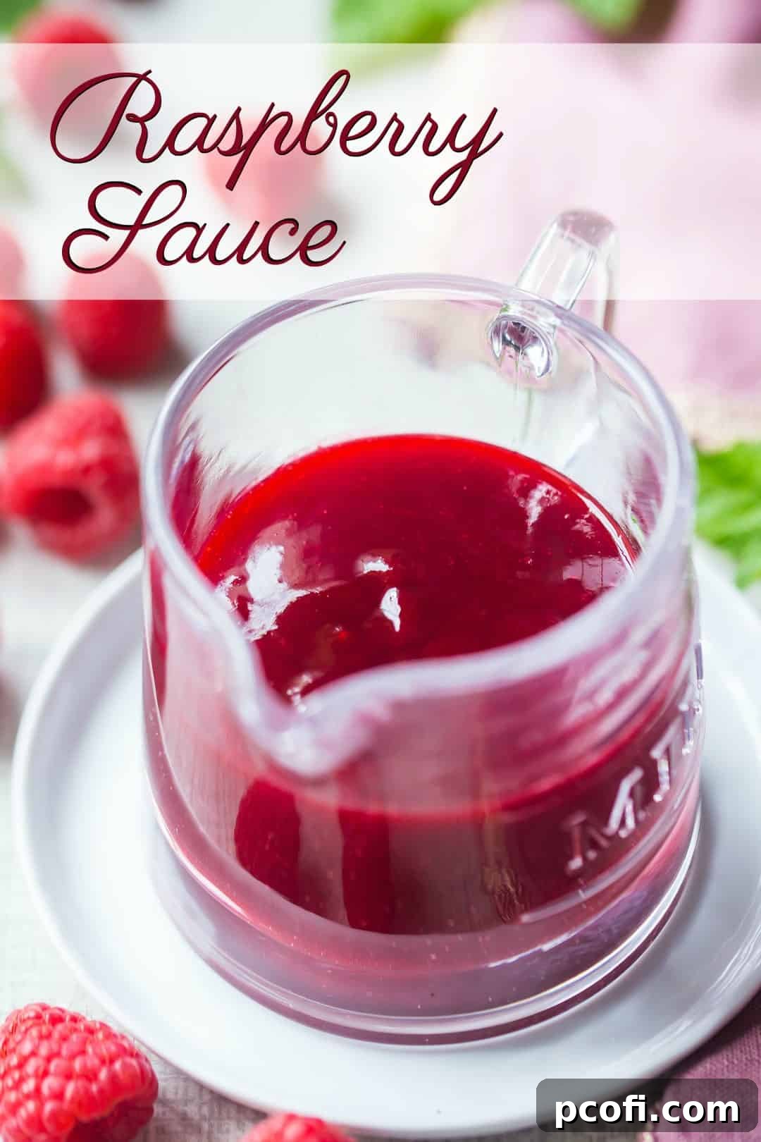 Small glass pitcher of seedless raspberry sauce, with a text overlay above that reads "Raspberry Sauce," emphasizing its smooth, luxurious texture.
