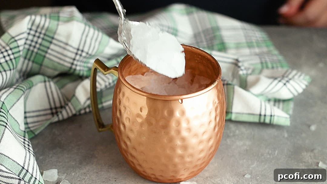 Filling a copper mug with crushed ice.