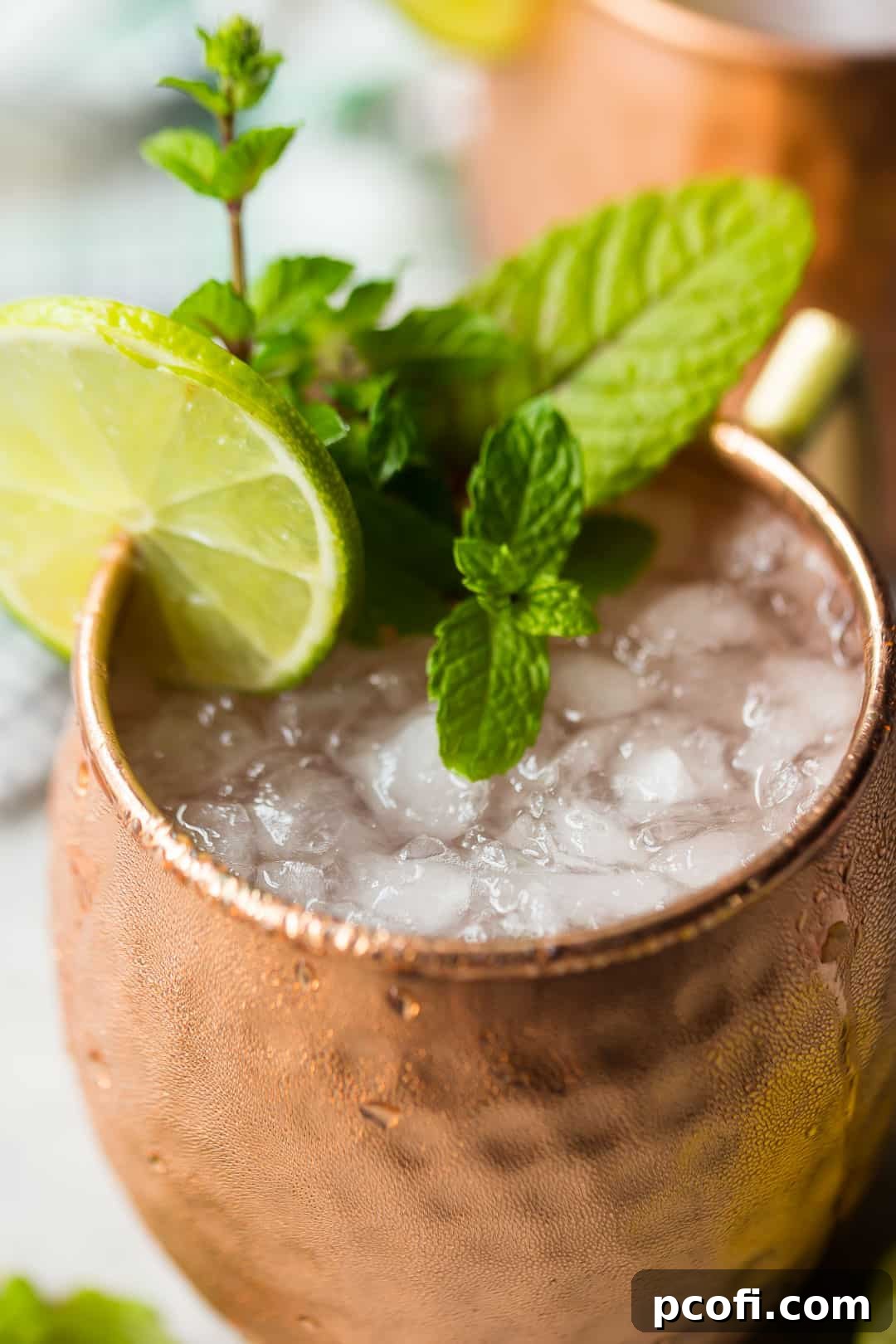 Close up image of a Moscow Mule drink with crushed ice, lime juice, and fresh mint.