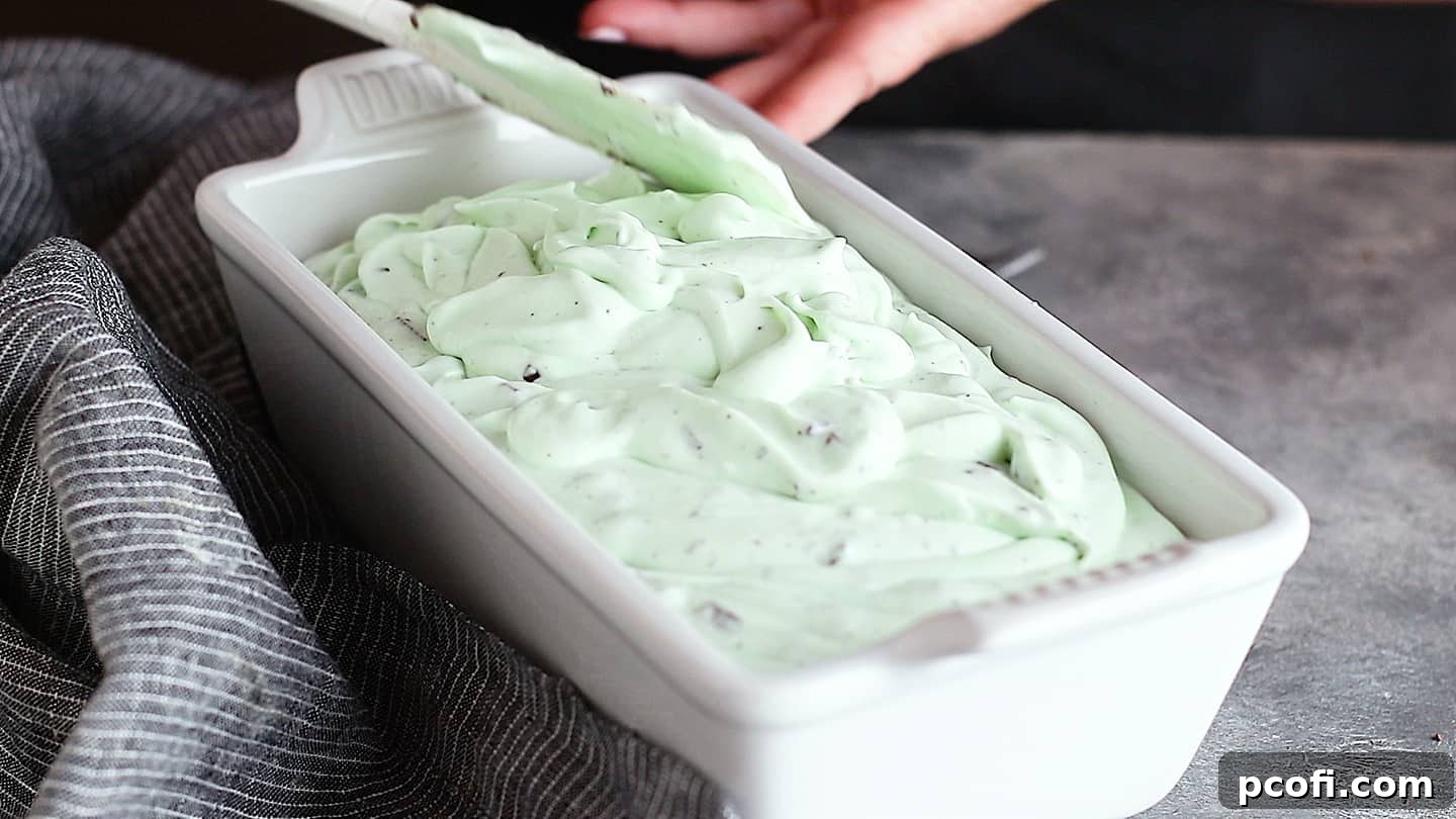 Mint chocolate chip ice cream base in a white loaf pan, ready to be frozen and transformed into a delectable dessert.