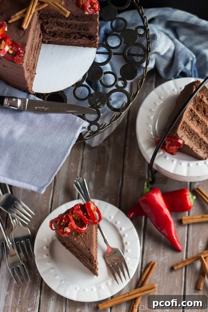 Slice of Mexican chocolate layer cake with whipped ganache and candied serrano peppers