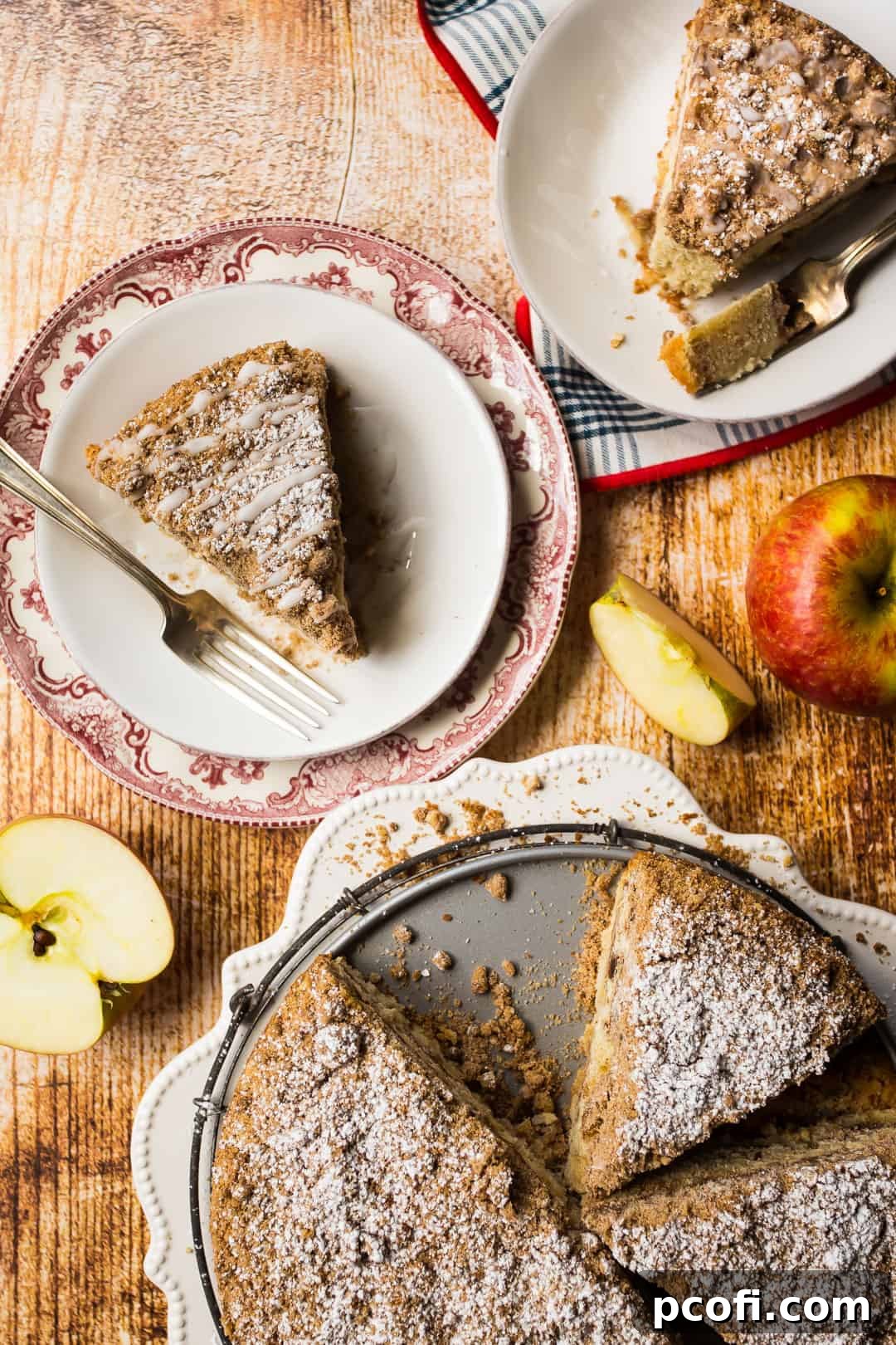 Multiple slices of delicious apple cinnamon coffee cake are arranged on various plates, with fresh whole apples scattered artfully nearby, highlighting the cake's key ingredients.