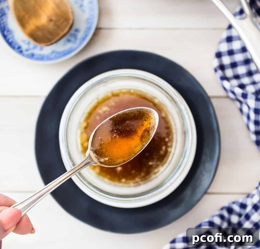 Overhead image of a spoonful of brown butter over a bowl with a blue checkered napkin.