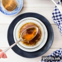 Overhead image of a spoonful of brown butter over a bowl with a blue checkered napkin.