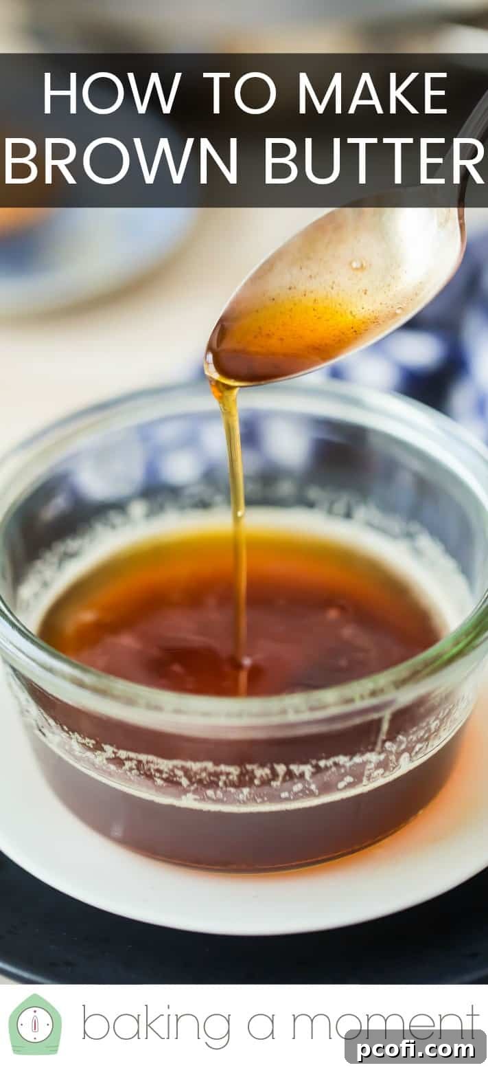 Drizzling brown butter from a silver spoon into a glass bowl.