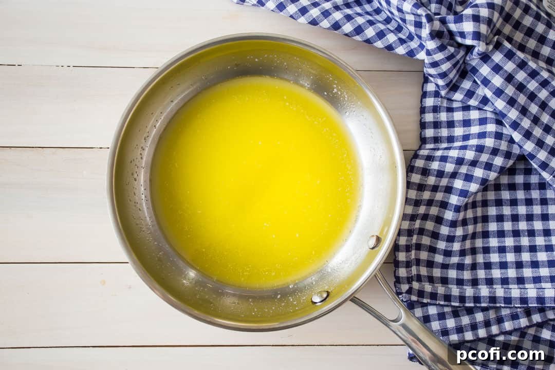 Melted butter in a small stainless steel skillet.