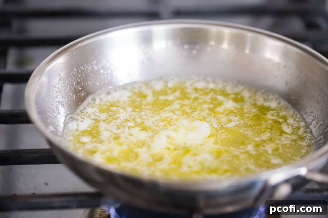 Boiling butter in a small stainless steel skillet.