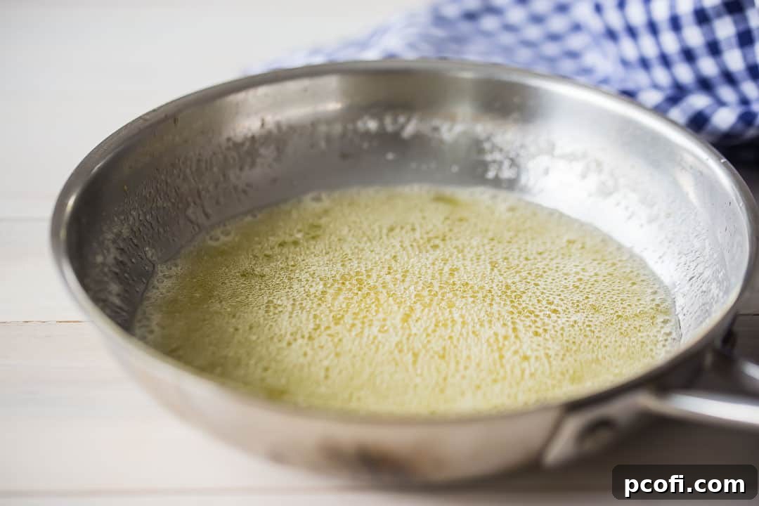 Foaming butter in a small stainless steel skillet.