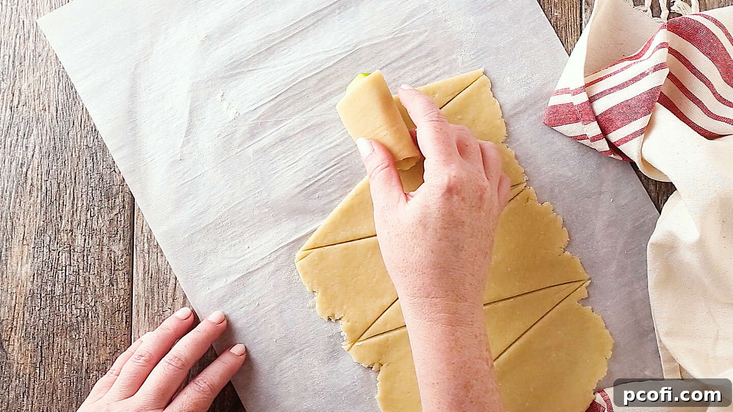 Rolling fresh apples in pastry for apple dumplings, a crucial step for perfect assembly.