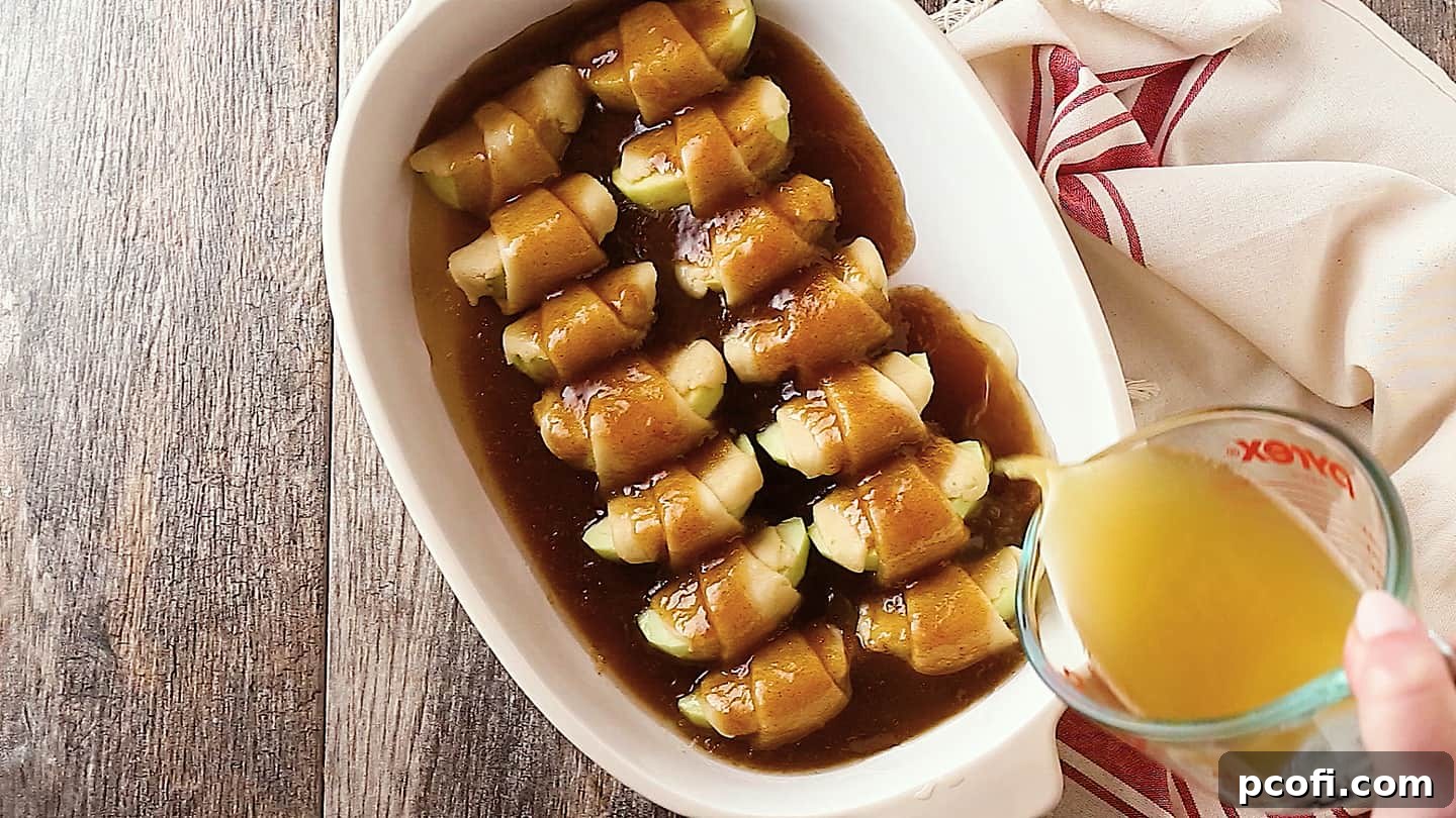Pouring apple cider around homemade apple dumplings in the baking dish, adding moisture and flavor.