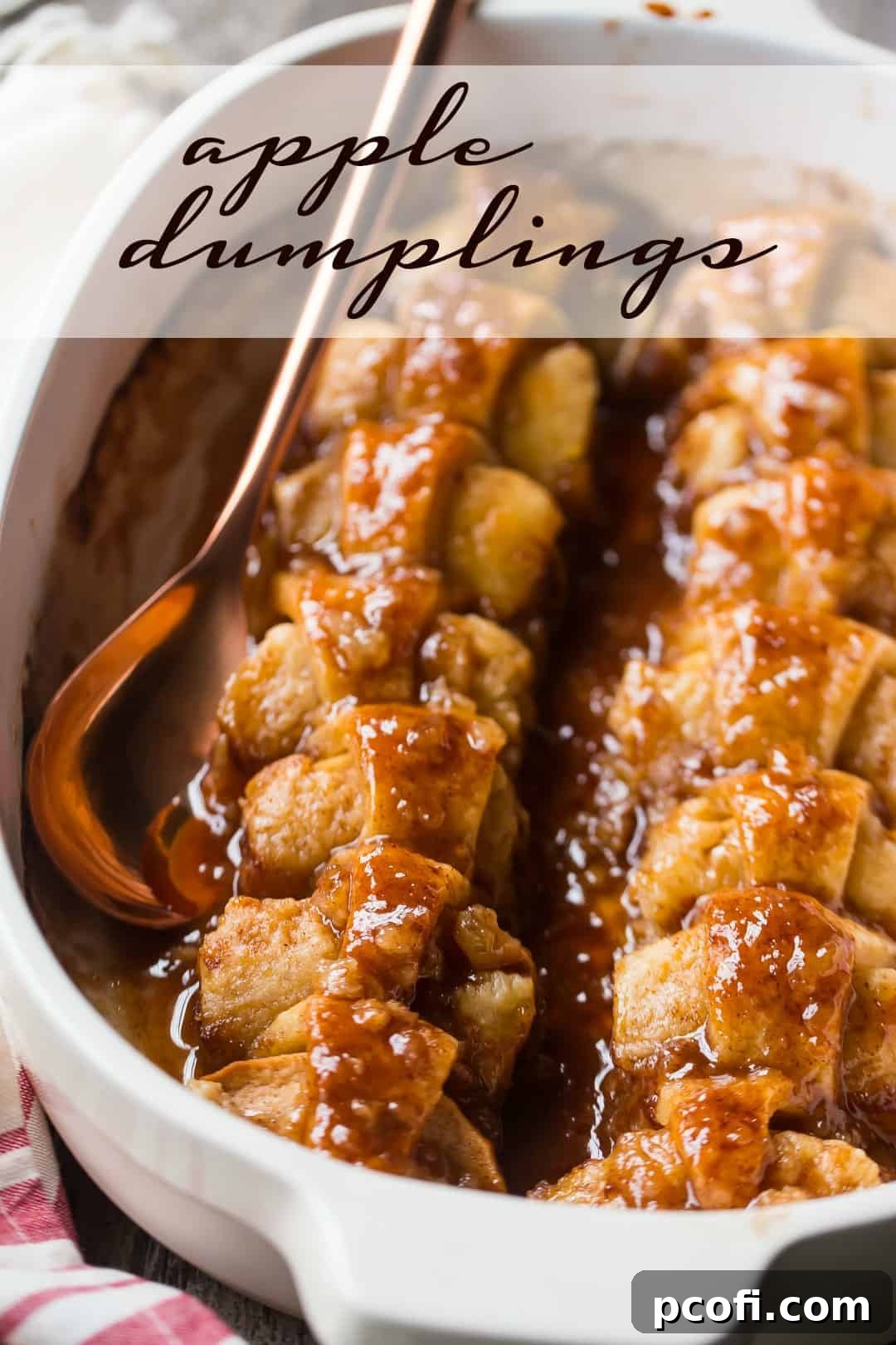 Apple dumpling recipe baked in a cream-colored ceramic dish, with a copper serving spoon and a text overlay above reading "Apple Dumplings." Highlighting the rich brown sugar sauce and golden pastry.