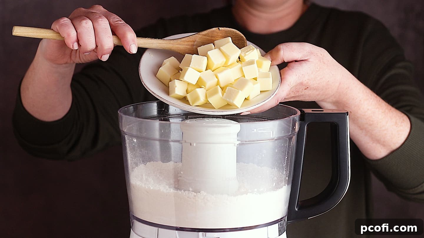 Adding cold butter to the food processor to make apple dumpling pastry. Key for a flaky texture.