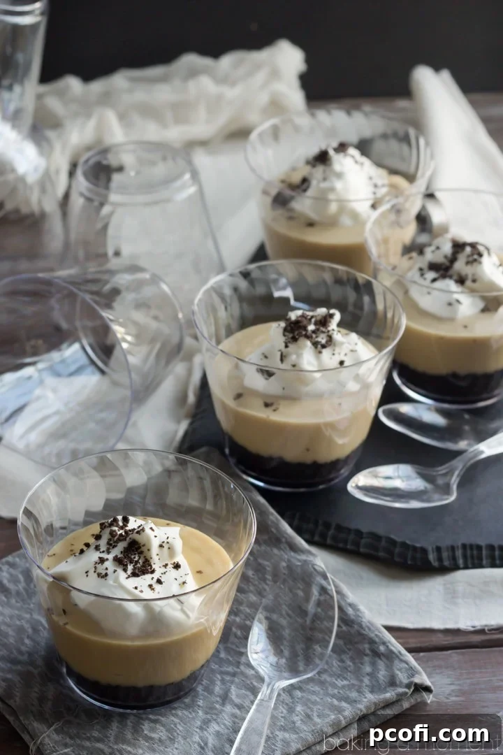 Individual serving of salted caramel pudding in a glass cup, topped with generous whipped cream and ready to be served.