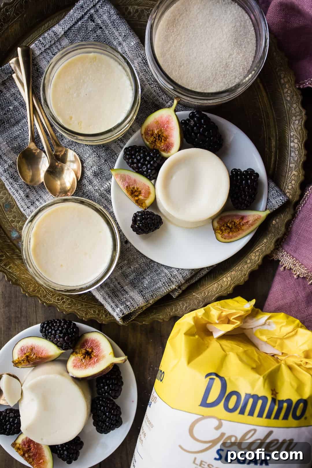 Classic panna cotta recipe, on a wooden table with golden sugar and small gold dessert spoons.