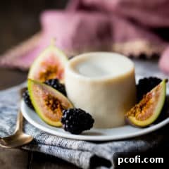 Panna Cotta on a small plate with fresh figs and blackberries.